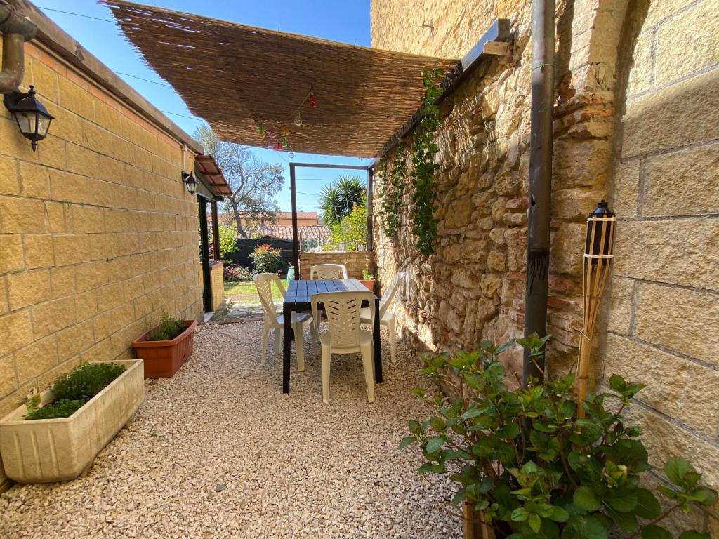 un patio con una mesa y una pared de piedra en Apartment Angolino di Borgo by Interhome, en Montescudaio