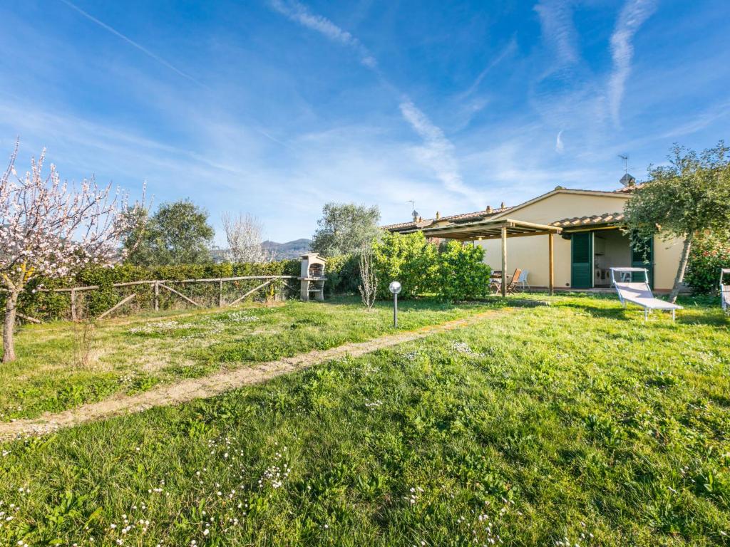 a yard with a house and a chair at Apartment Lavender by Interhome in Santa Luce