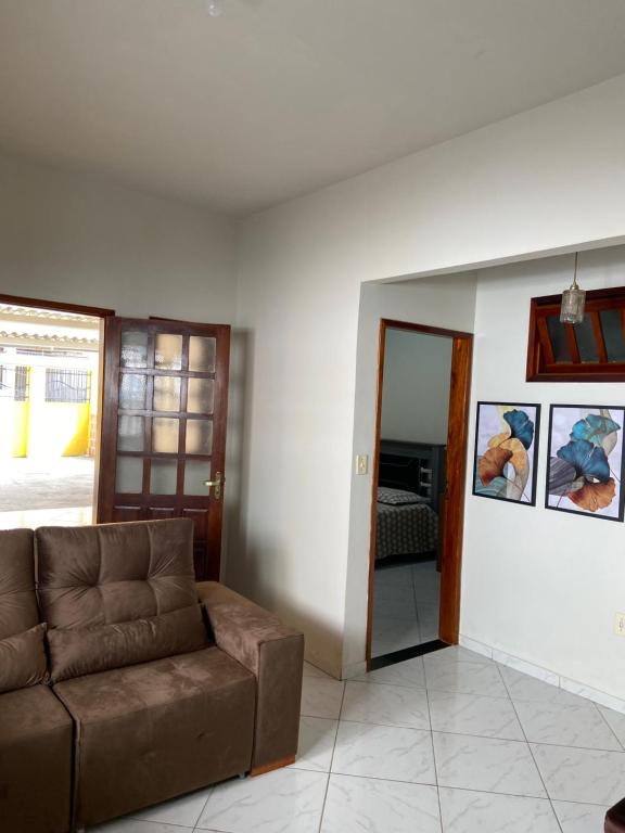 ein Wohnzimmer mit einem braunen Sofa und einem Spiegel in der Unterkunft Casa agradável no centro in Bananeiras