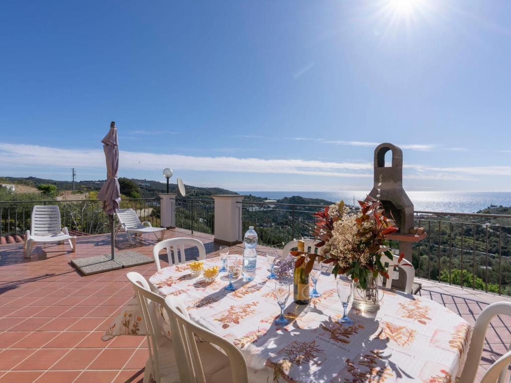 a table with a vase of flowers on a patio at Apartment Aurora by Interhome in Costarainera