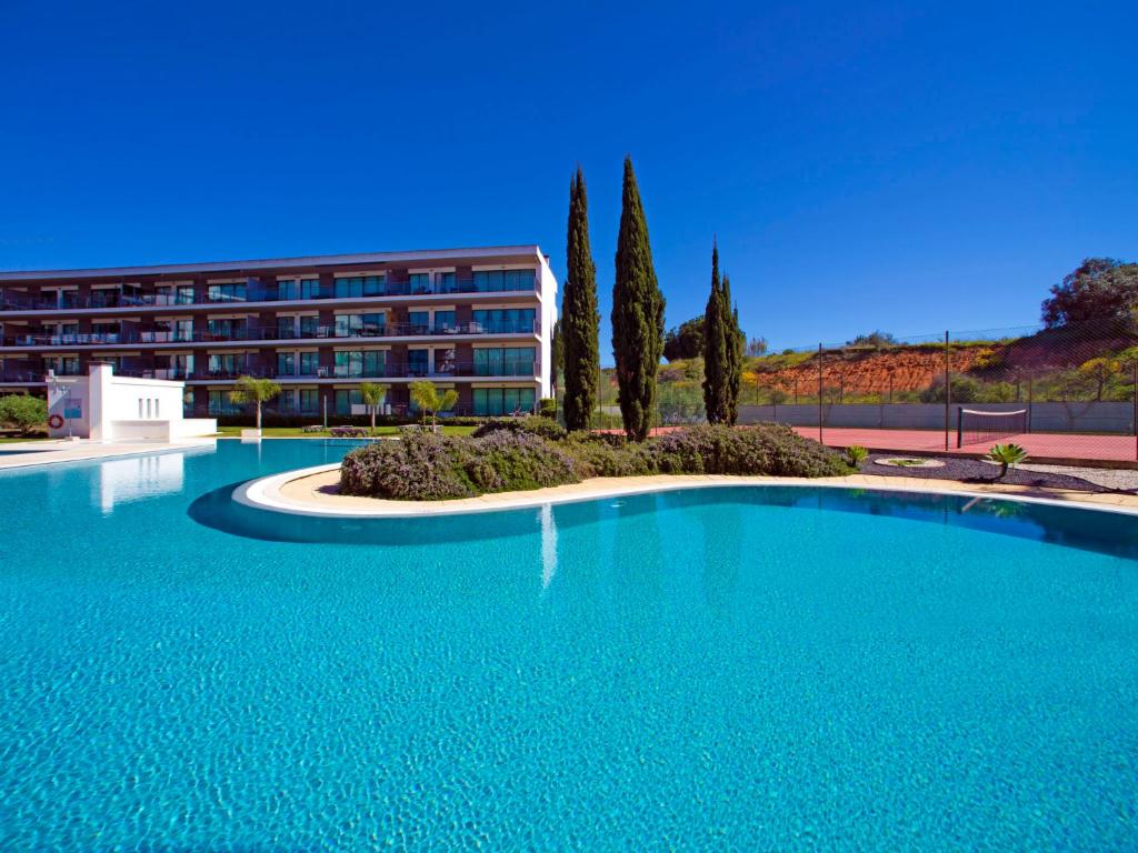 a large blue swimming pool in front of a building at Apartment Sunna Residence by Interhome in Vilamoura