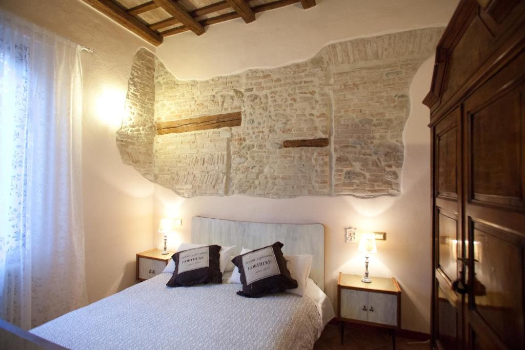 a bedroom with a white bed with two night stands at Relais B&B Corte Dei Turchi in Longiano
