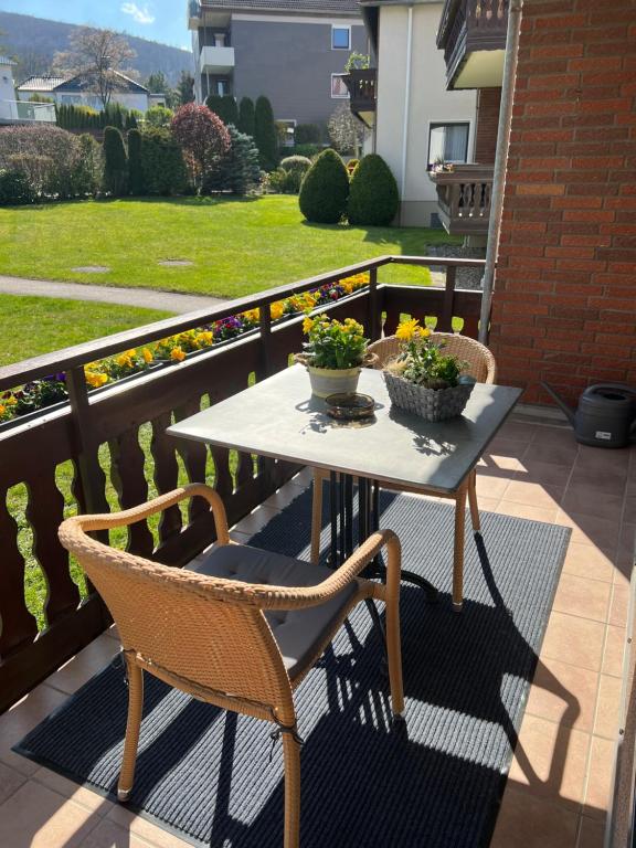 a table and chairs on a balcony with flowers at Viktoria‘s Ferienwohnung in Bad Harzburg