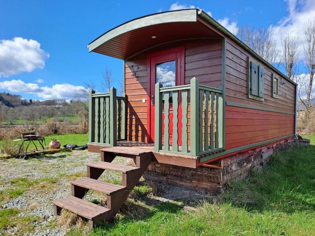 una pequeña casa con una escalera en un campo en La p'tite Bohème, en Gouttières