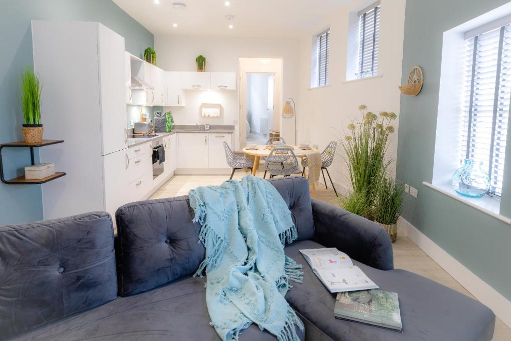 a living room with a blue couch and a kitchen at Courtyard Retreat in Southampton