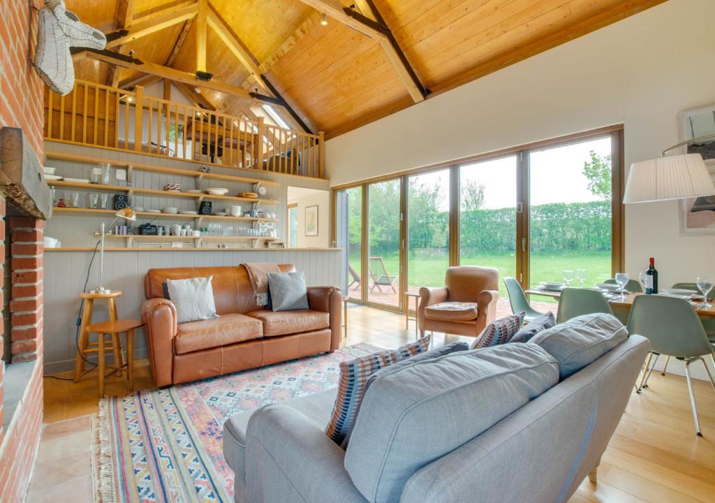 a living room with a couch and a table at The Folly Barn in Debenham