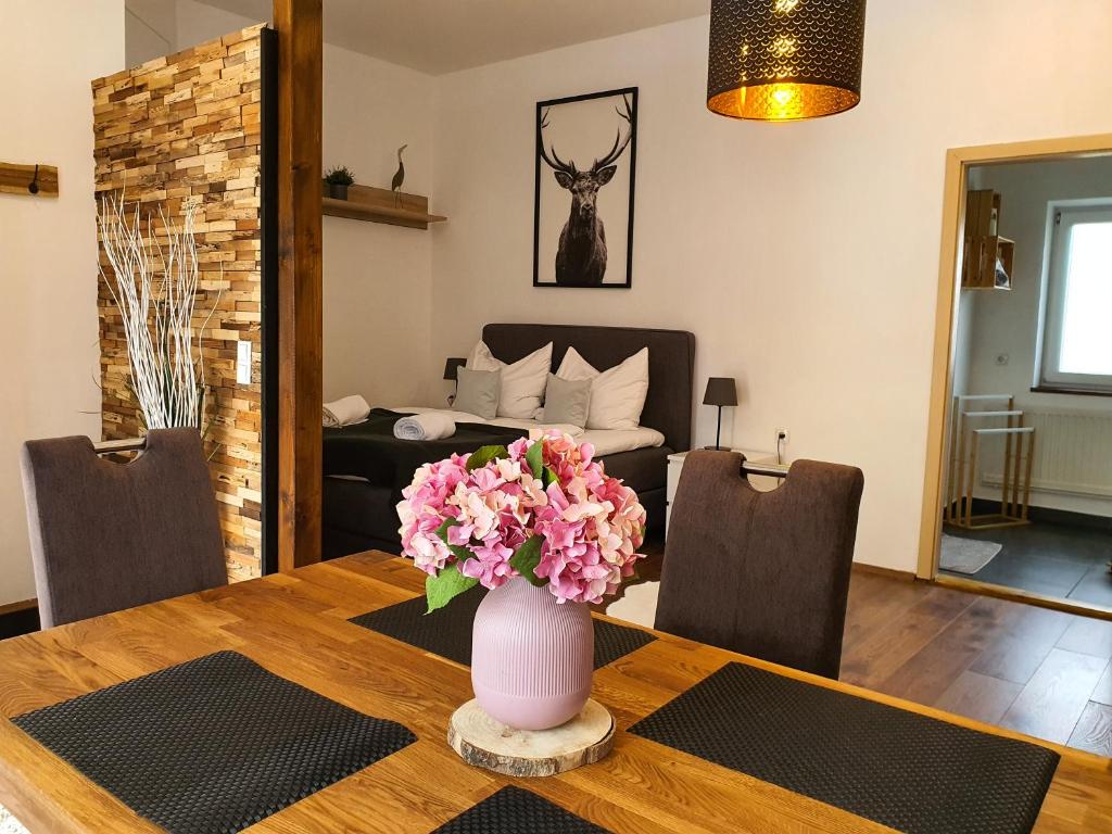 a dining room table with a vase of flowers on it at Kozma Apartments Peterlewand in Bodensdorf