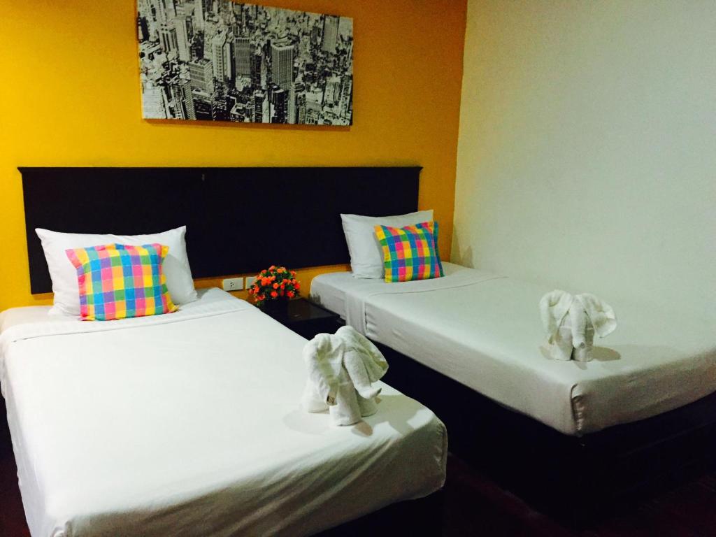 duas camas num quarto com elefantes de peluche em Benetti Lodge em Patong Beach