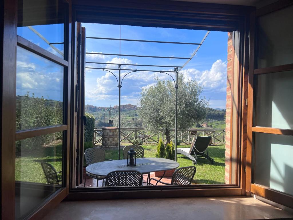 CastelmuzioにあるCasa Valerieのテーブルと椅子、大きな窓が備わる客室です。