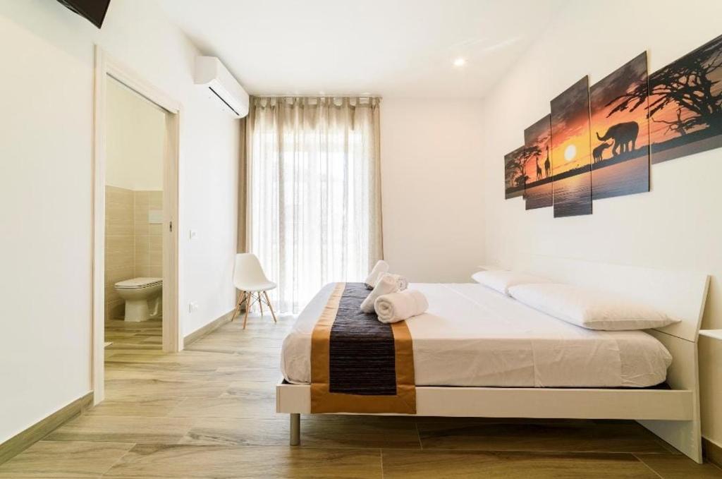 a white bedroom with a bed and a bathroom at Il Giramondo in Agropoli