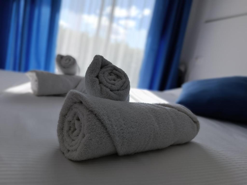 einen Stapel Handtücher auf dem Bett in der Unterkunft Casetta alla Spiaggia Ventimiglia in Ventimiglia