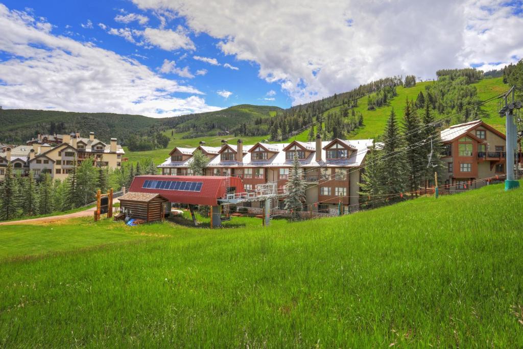 a group of houses on a hill with green grass at The Osprey at Beaver Creek, a RockResort in Beaver Creek