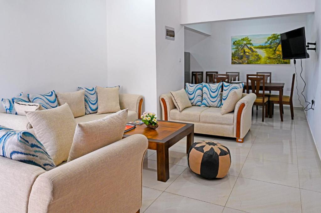 een woonkamer met 2 banken en een tafel bij Lake Red 6 Apartments & Hotel in Nugegoda