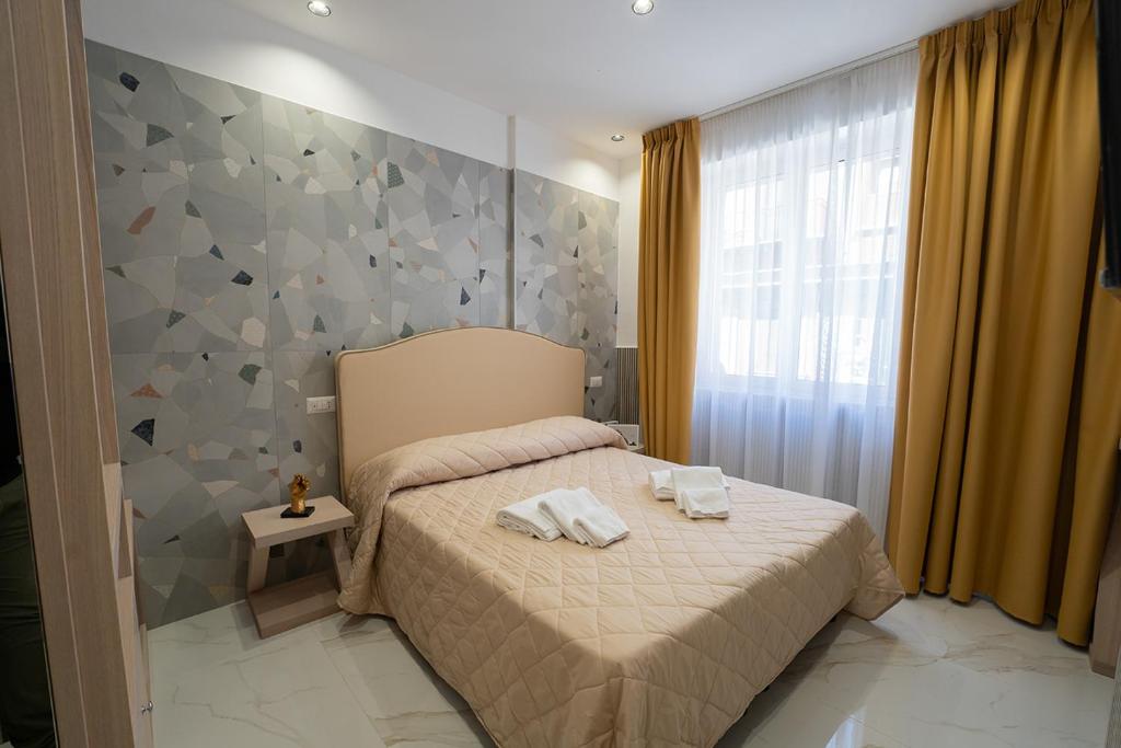 a bedroom with a bed with two towels on it at GreRos H. Rooms Napoli Centro by Clapa Group Dislocated Hospitality in Naples