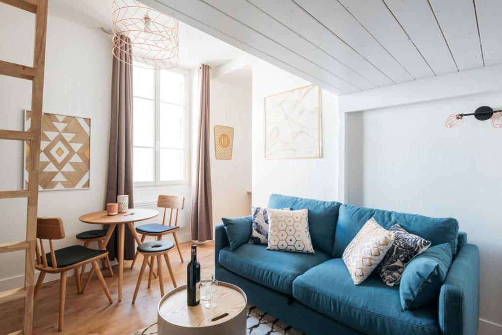 a living room with a blue couch and a table at Le petit Bancel- Jean Macé in Lyon