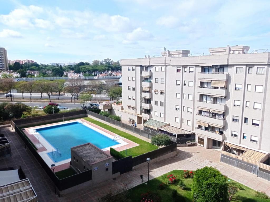 uma vista superior de uma piscina em frente a um edifício em Apartamento Jerez Norte em Jerez de la Frontera
