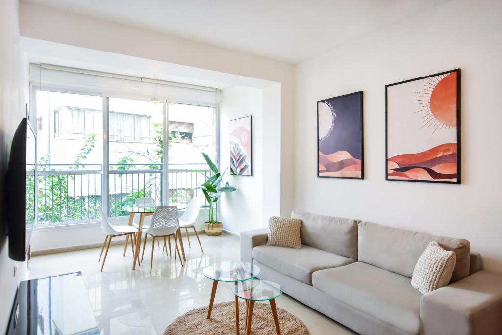 a living room with a couch and a table at Morning light near gordon beach by HolyGuest in Tel Aviv