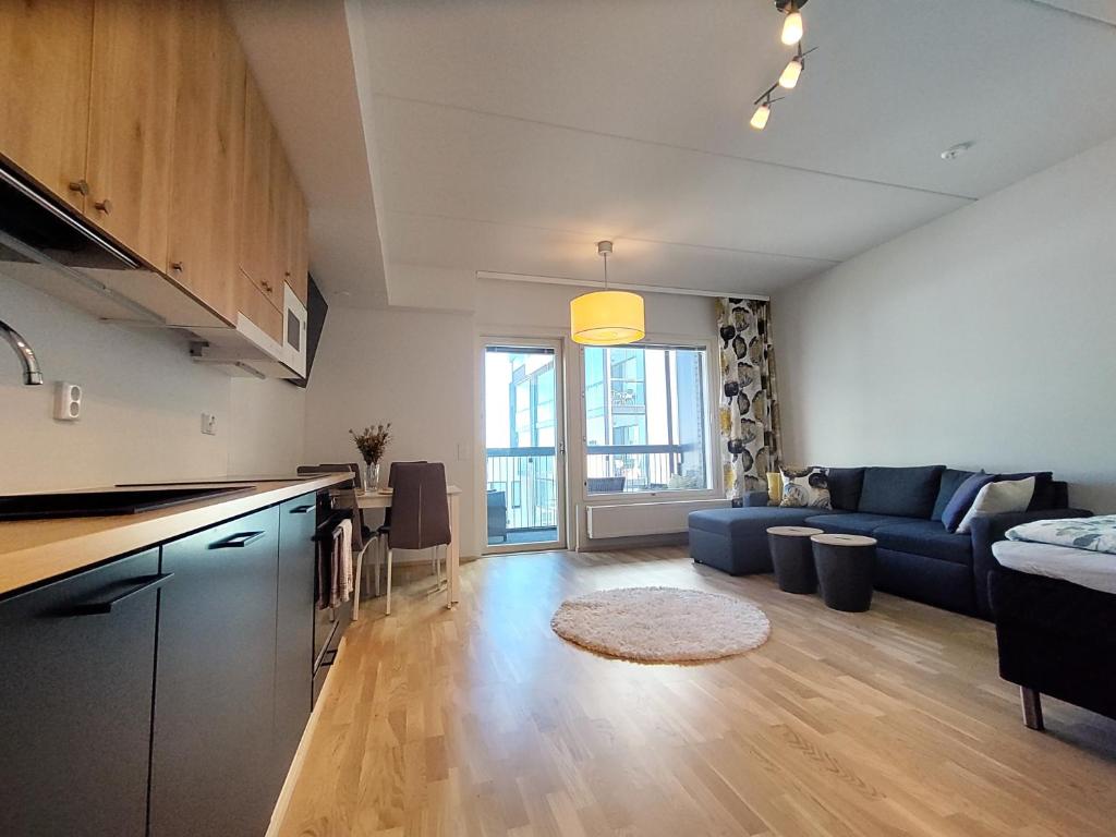 een keuken en een woonkamer met een bank en een tafel bij Fully Equipped New Apartment With Free Parking in Tampere