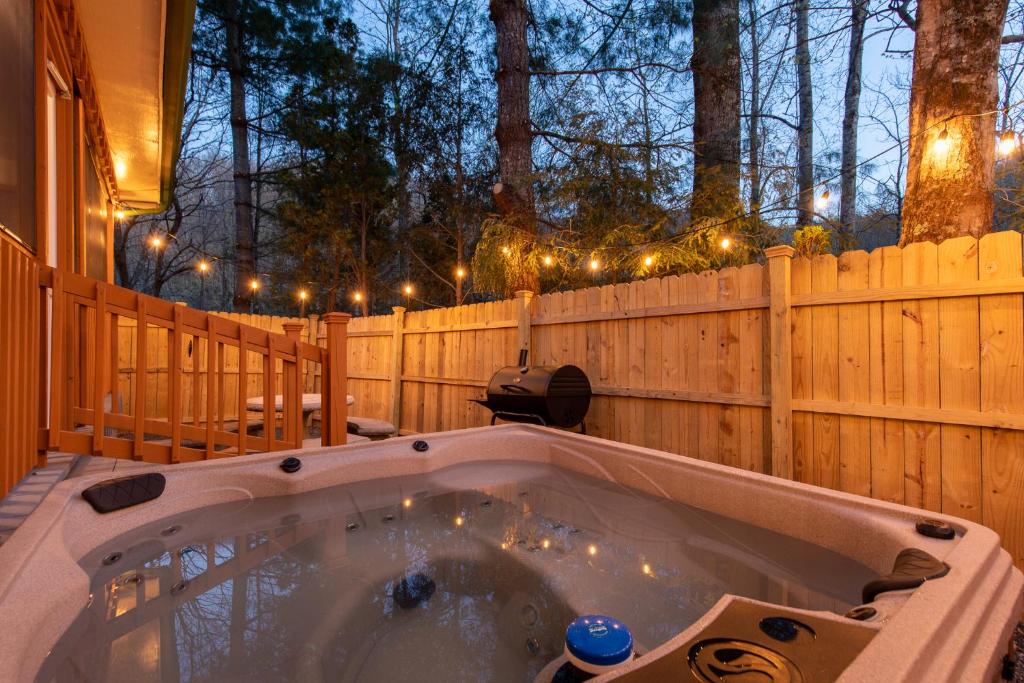 - un bain à remous dans une arrière-cour dotée d'une clôture et de lumières dans l'établissement Jireh Mount Cabin, à Cosby