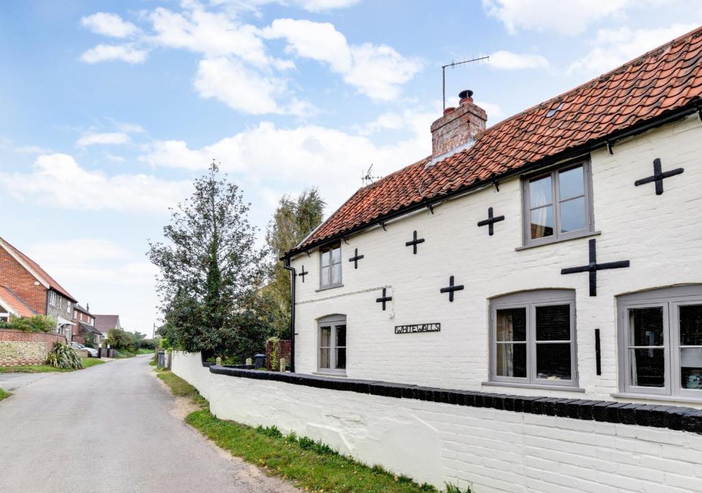 a church with crosses on the side of a white building at Whitewalls in Snape