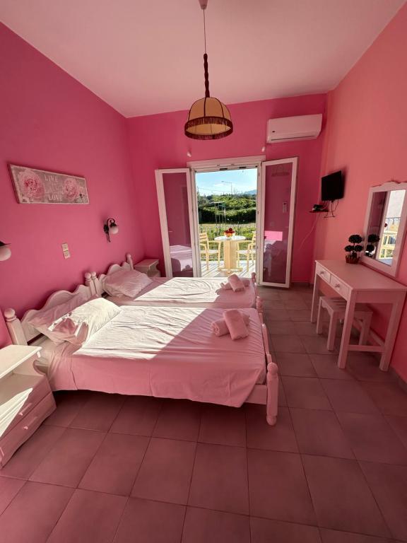 a bedroom with a large bed and a pink wall at Telis Apartments One in Roda