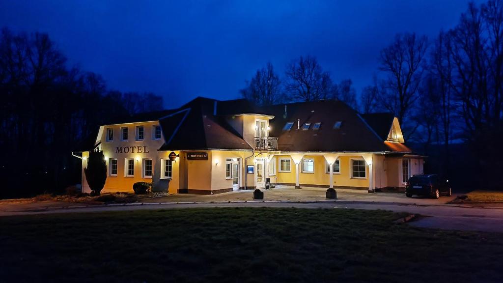 een groot wit gebouw met 's nachts verlichting bij Motel Velký Rybník in Pelhřimov