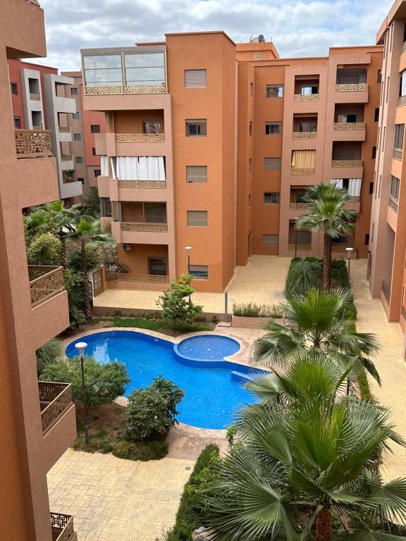 un complexe d'appartements avec piscine et palmiers dans l'établissement Appartement moderne avec piscine à Marrakech, à Marrakech