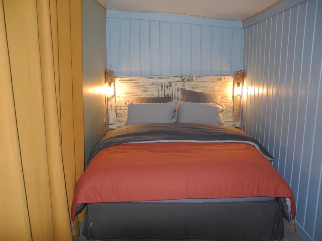 um quarto com uma cama com uma parede azul em Art et Nature em Abbeville