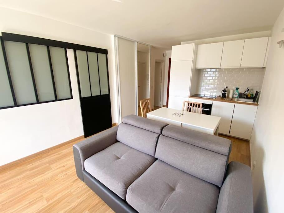 a living room with a couch and a kitchen at Walk to Beach T2 Climatisé, Vue mer, Parking Privé in Roquebrune-Cap-Martin