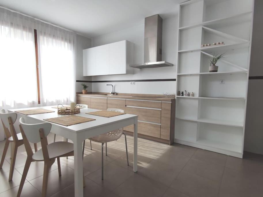 a white kitchen with a white table and chairs at Apartamento Exclusivo San Marcos in Manzanares