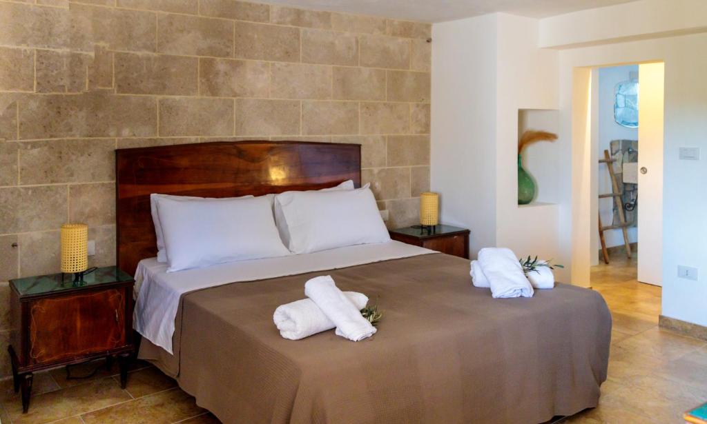 1 dormitorio con 1 cama con toallas en B&B Dimora Castello, en Galatone