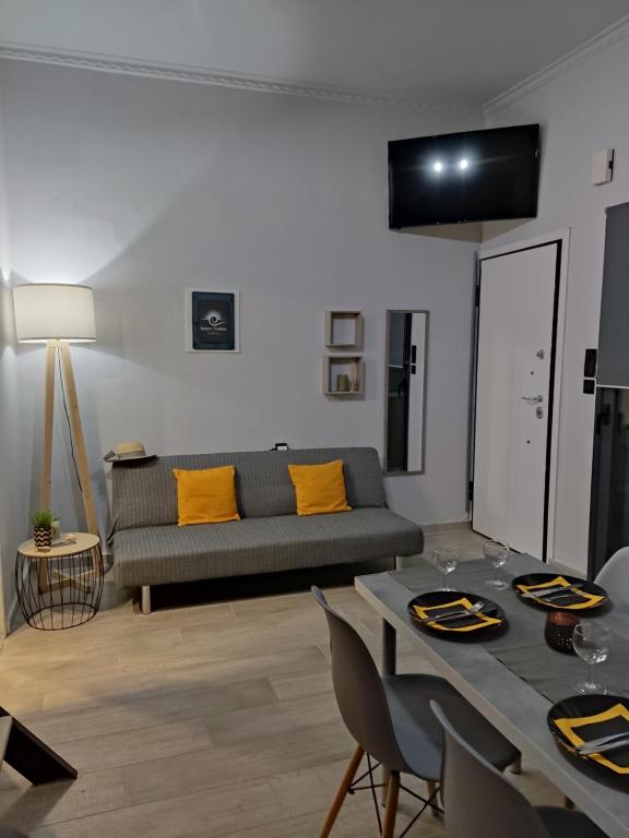 a living room with a couch and a table with yellow pillows at ISMINI STUDIOS in Menídion