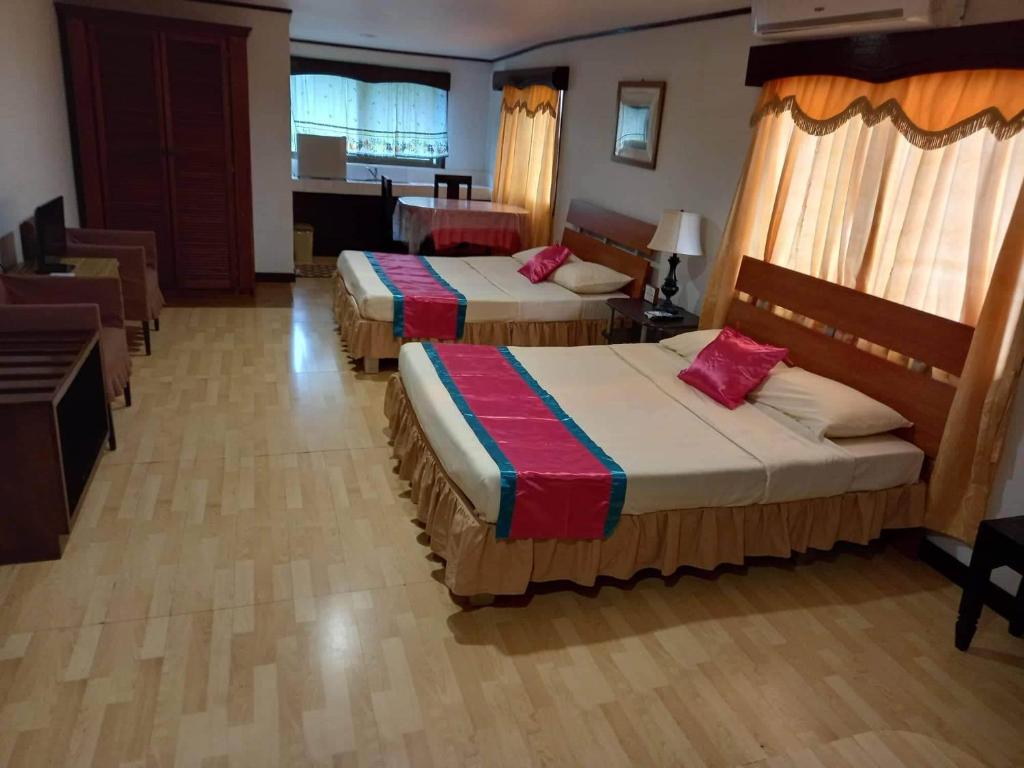 Habitación de hotel con 2 camas y mesa en LEHNS MOTEL en Koror