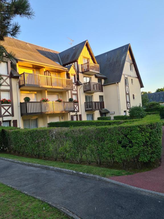 un gran edificio con balcones al lado de una carretera en Charmant studio proche de la mer, en Tourgéville