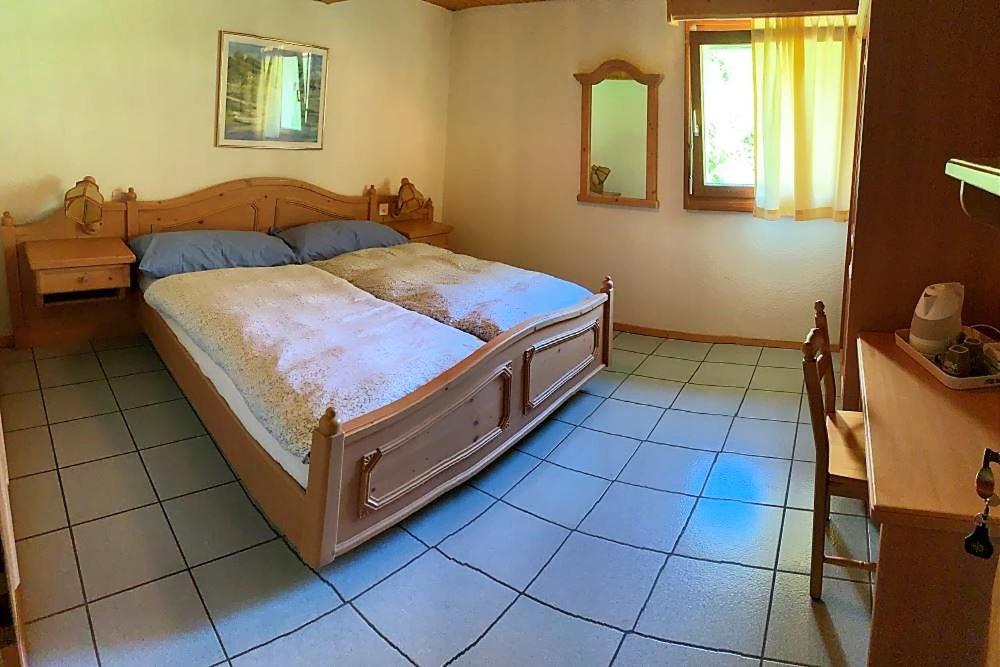 a bedroom with a large bed in a room at OSTERIA RUBINO DA PAOLO in Acquarossa