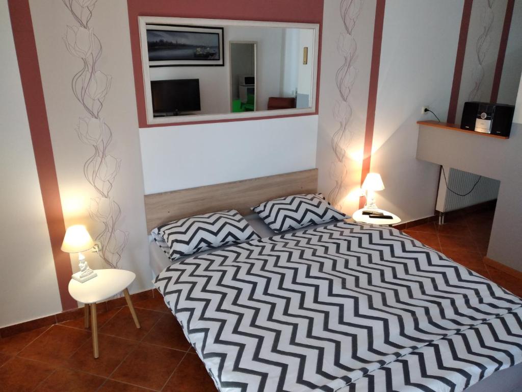 a bedroom with a black and white bed and a mirror at Apartments Košević in Osijek