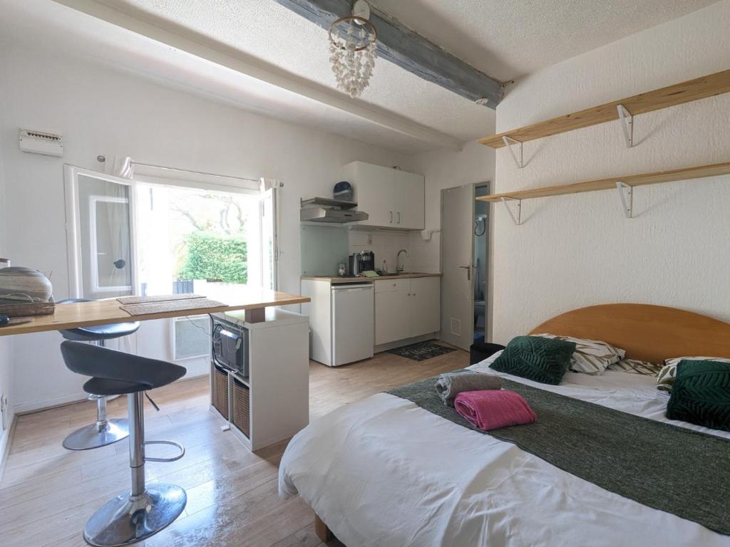 a bedroom with a bed and a desk in it at STUDIO avec PARKING TOUT A PIED et CALME in Bandol