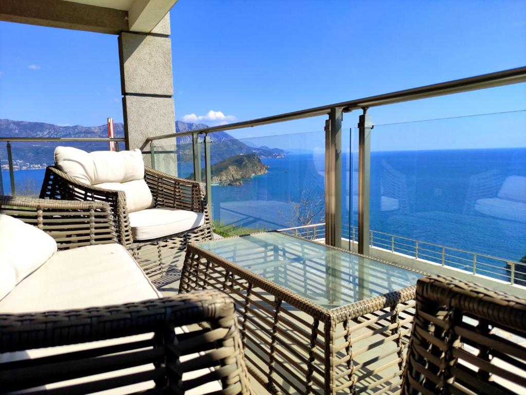 a balcony with chairs and a glass table at Nature Escape Amazing Sea View in Budva