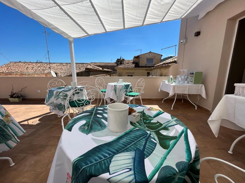 a patio with tables and chairs and a view of the ocean at De LoCa Rooms in Tropea