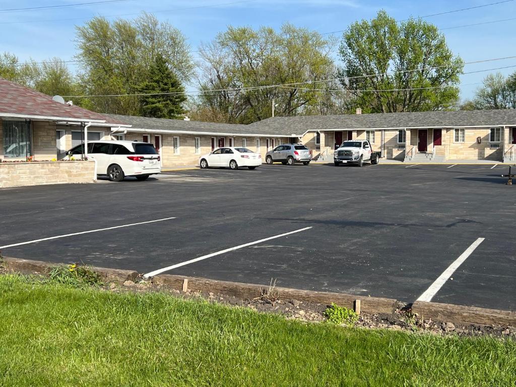 a parking lot with cars parked in front of a building at Bestway Inn in Muncie