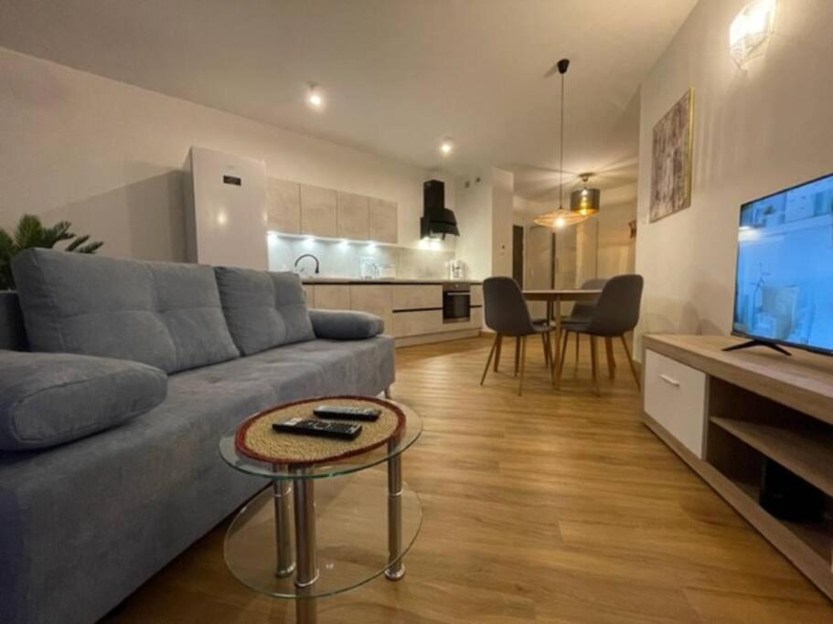 a living room with a couch and a table and a kitchen at Zacisze apartament in Zielona Góra