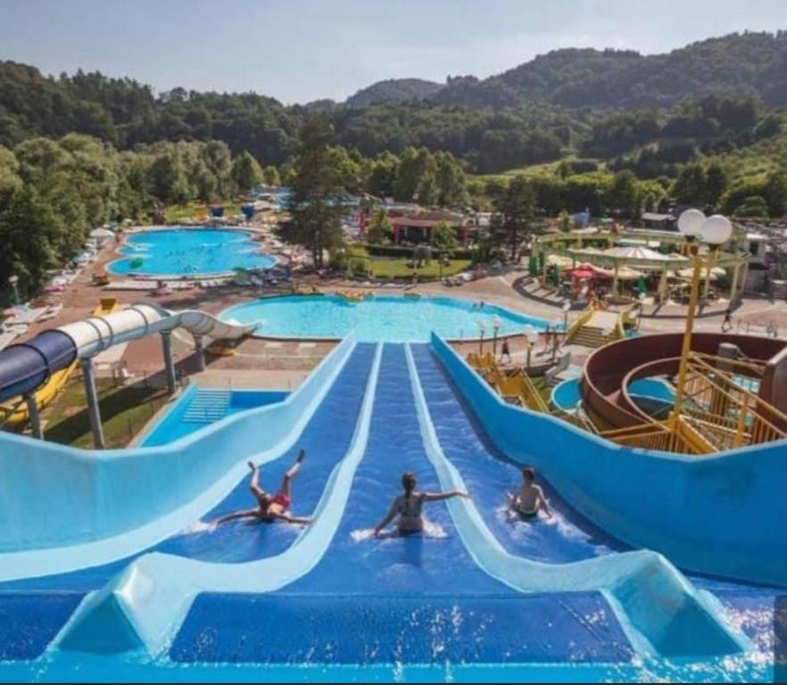 a water park with people riding down a water slide at G122 SREČNA HIŠKA Aqualuna & Terme Olimia Vstopnice in Podčetrtek