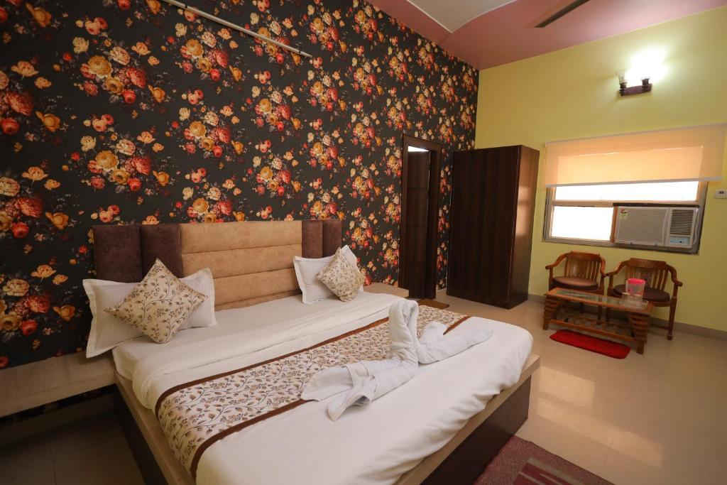 um quarto com 2 camas e uma parede floral em Hotel Mukund Priya- Near Krishna Janam Bhoomi em Mathura