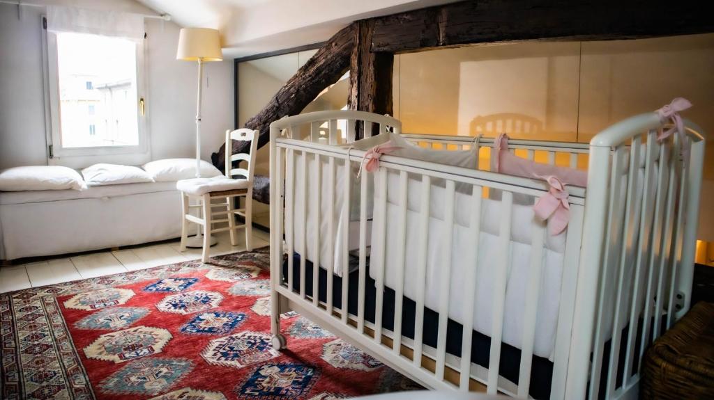 Habitación para bebés con cuna y sofá en La Finestra, en Bolonia