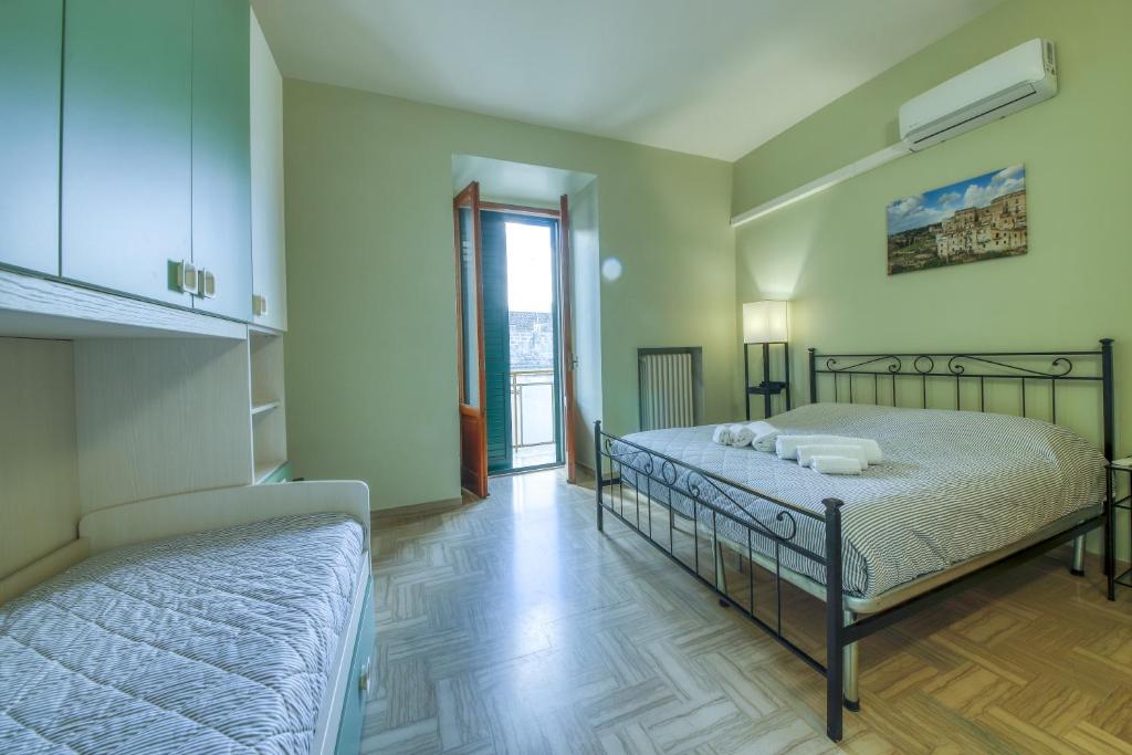 a bedroom with two beds and a balcony at Pellicciari 14 - Affitti Brevi Italia in Gravina in Puglia