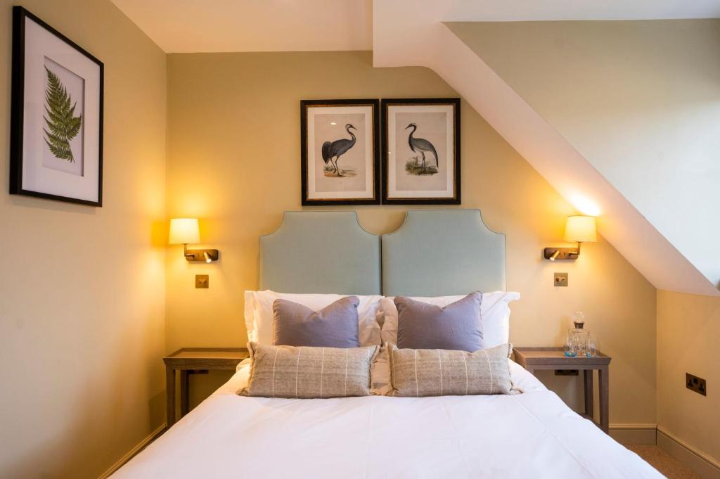um quarto com uma cama com três fotografias na parede em The Bottle & Glass Inn - Barn View - Room 2 em Henley on Thames