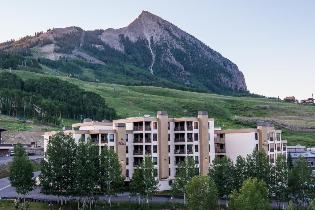 a large building in front of a mountain at The Plaza Condominiums by Crested Butte Mountain Resort in Mount Crested Butte
