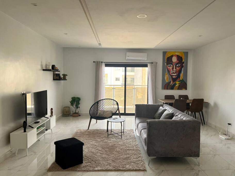 a living room with a couch and a dining room at 2br modern apartment in Almadies in Dakar
