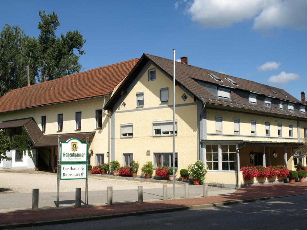 ein großes weißes Gebäude mit einem Schild davor in der Unterkunft Gasthof Ramsauer in Neufahrn in Niederbayern