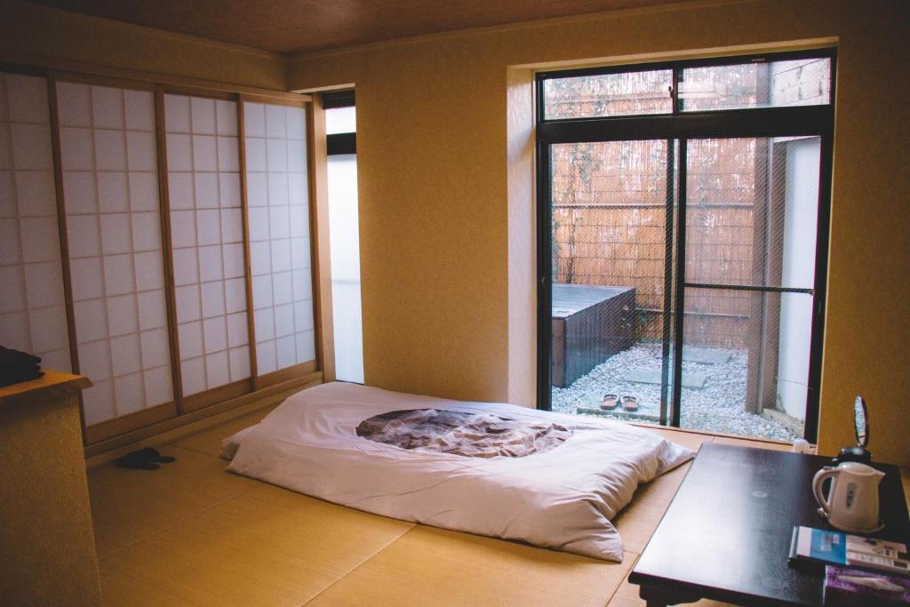 a room with a bed in front of a window at WASEIDOU ZEN - Vacation STAY 17260v in Kobe